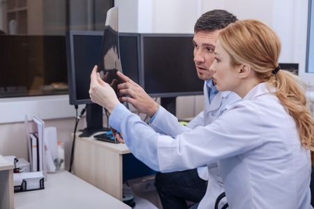 Nice professional doctors looking at the x ray photoの写真素材
