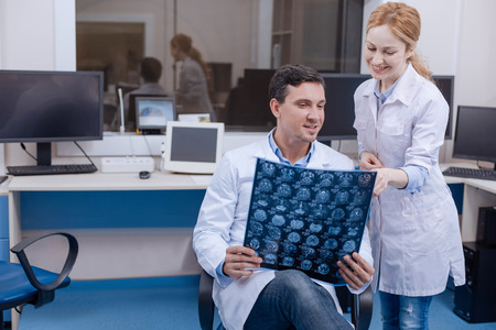 Delighted female doctor pointing at the X ray photo