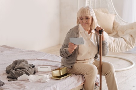 Sad unhappy woman holding a letterの写真素材