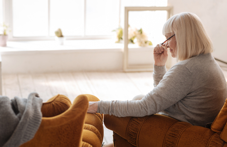 Good looking nice woman resting in the armchairの写真素材