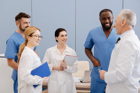 Elderly mentor enjoying teaching interns in medical universityの写真素材