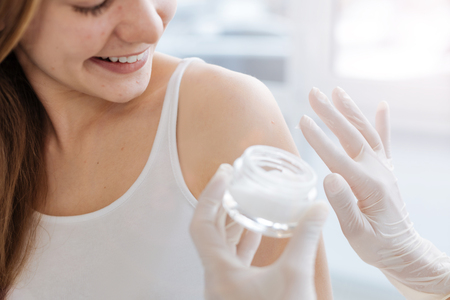 Cheerful young girl enjoying appointment to cosmetologist in the clinicの写真素材