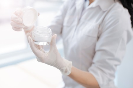 Female medical specialist holding the jar of cream in the clinicの写真素材
