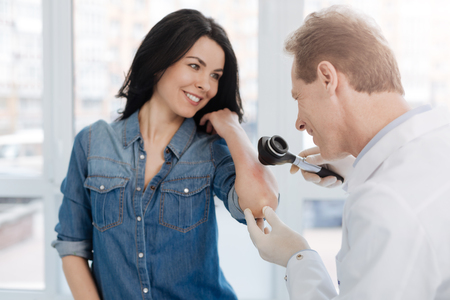 Smiling dermatologist enjoying appointment with patient in the hospitalの写真素材