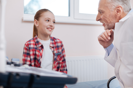 Optimistic girl enjoying visit to the physician in the hospitalの写真素材