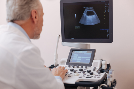Concentrated doctor using equipment for sonography in the hospitalの写真素材