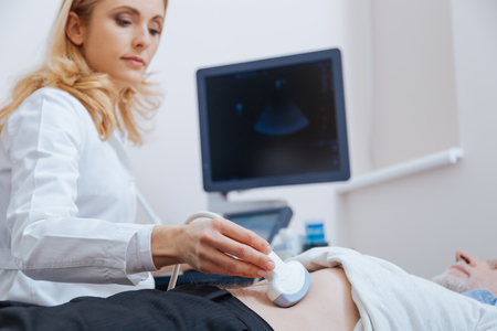 Proficient physician using ultrasound machine in the clinicの写真素材