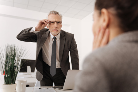 Very attentive office worker narrowing his eyesの写真素材