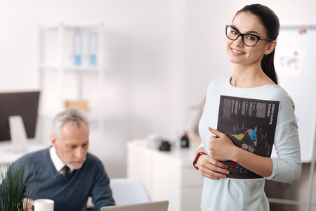 Beautiful office worker holding geographical map in left handの写真素材