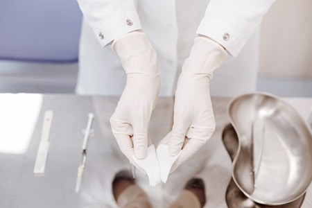 Close up of a doctor wearing disposable glovesの写真素材