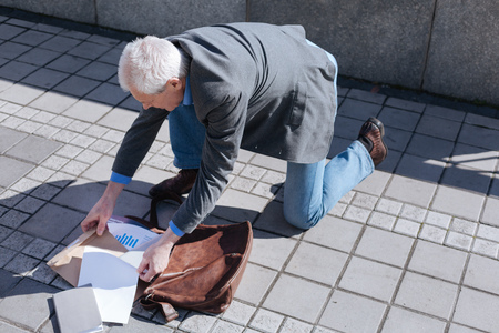 Bewildered man quickly vetting his handbag in the parkの写真素材