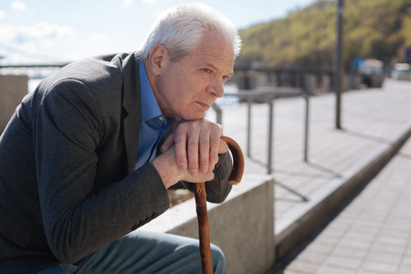 Serious pensioner relaxing outdoorsの写真素材