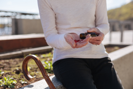 Stylish lady taking pills from dizziness outdoors