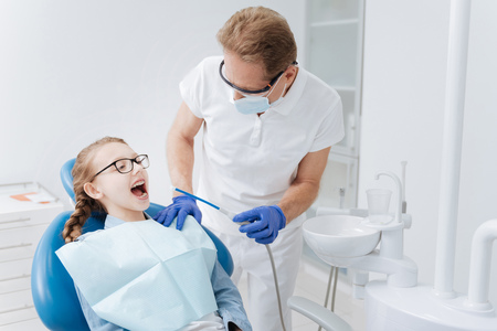 Mindful delicate dentist asking how his patient feelingの写真素材
