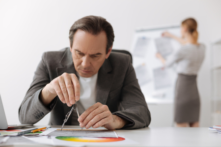 Concentrated serious engineer drawing in the officeの写真素材