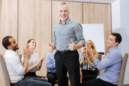 Cheerful handsome man showing thumbs up gestureの写真素材