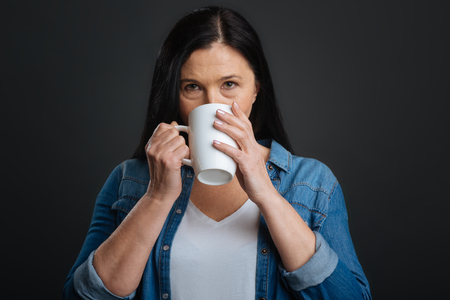 Elegant gorgeous woman enjoying hot drinkの写真素材