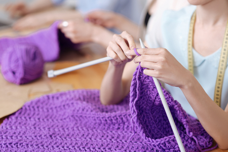 Delicate beautiful female hands knittingの写真素材