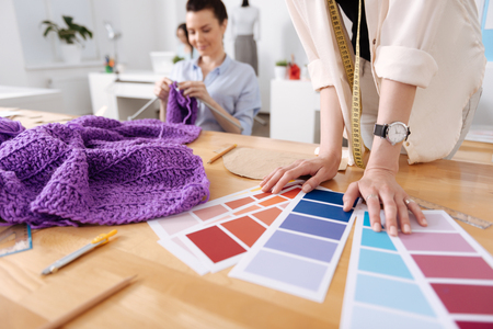 Delicate hands of a tailor on the working tableの写真素材