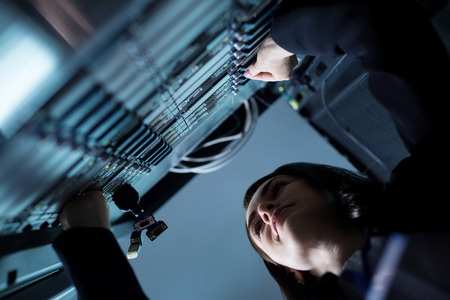 Nice pleasant woman standing near the network serverの写真素材