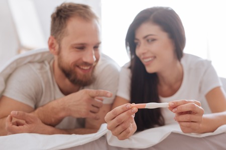 Young man and woman chatting about pregnancy in bed