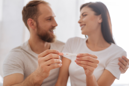 Young couple showing pregnancy test togetherの写真素材