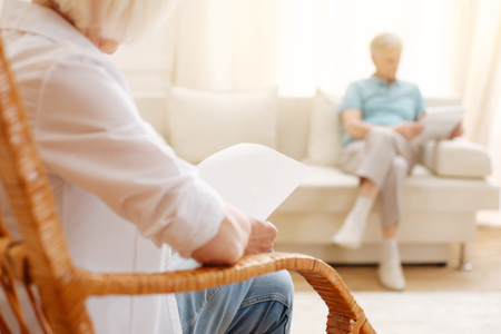 Attentive aged woman reading somethingの写真素材