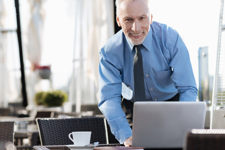Attractive man standing near his computerの写真素材