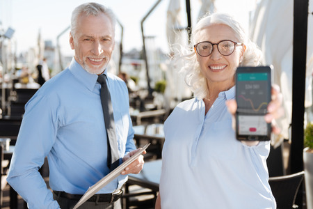 Delighted female demonstrating good results in tradingの写真素材