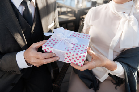 Close up of male hands while presenting special box.の写真素材