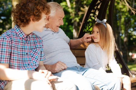 Pretty girl looking at her favorite grandfatherの写真素材