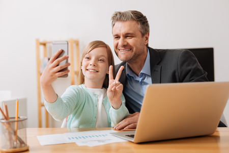 Cute child and her parent making a picture togetherの写真素材