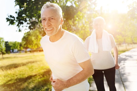 Cheerful retired man jogging with his wifeの写真素材
