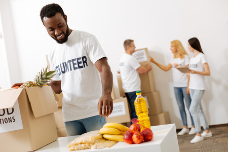 Energetic altruistic man helping packing suppliesの写真素材