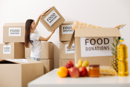 Charming sweet lady taking a box to fillの写真素材