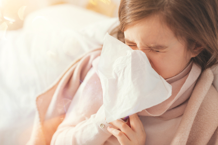 Sick girl covering her nose with paper servietteの写真素材