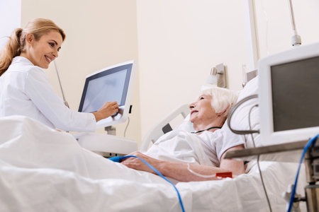 Sweet qualified doctor talking to her bright patientの写真素材