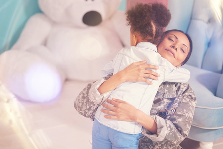 Happy child hugging her mother tightly