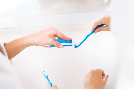 Close up of female hand that pouring toothpasteの写真素材