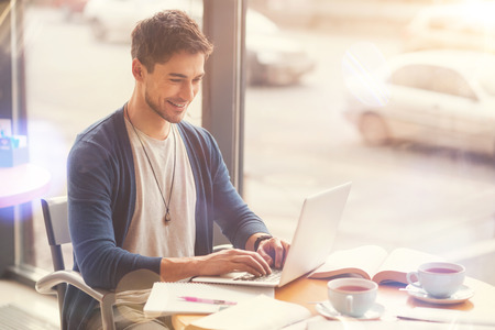 Positive freelance student sitting in the cafeの写真素材