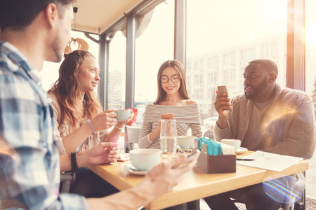 Cheerful international students resting in the cafeの写真素材