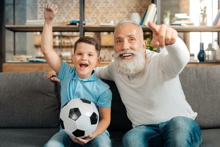 Grandfather and grandson celebrating important goalの写真素材