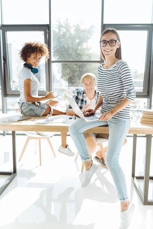 Cheerful smart woman studying with her groupmatesの写真素材