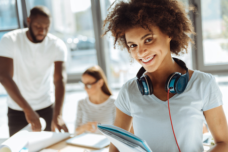 Positive female afro american student holding her notebookの写真素材