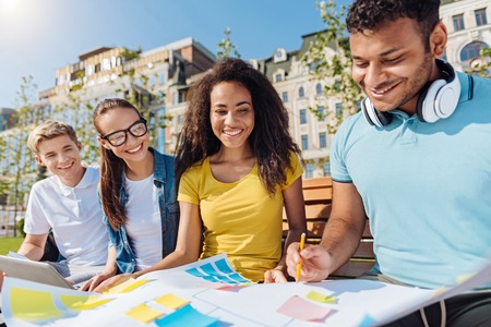 Delighted group mates looking at new planの写真素材