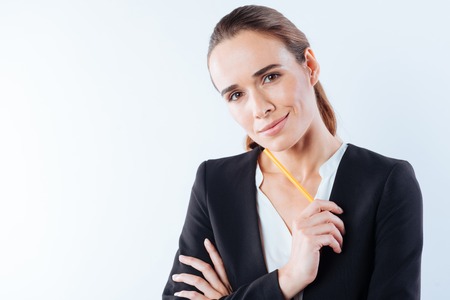 Delighted pretty woman holding a pencilの写真素材