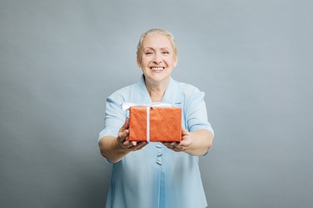 Positive delighted woman demonstrating red boxの写真素材