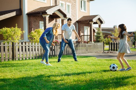 Little girl playing football with her parentsの写真素材