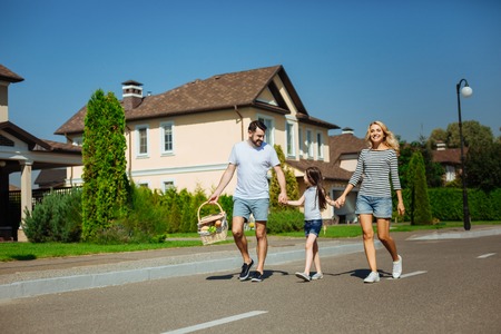Happy family holding hands and going on a picnicの写真素材