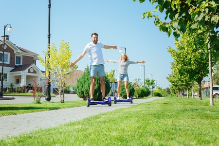 Happy young couple enjoying hoverboard rideの写真素材